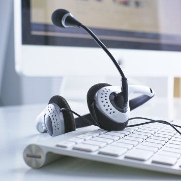 voip services best voip providers computer with headset on white keyboard monitor in the background